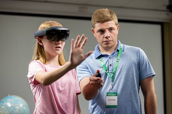 Student teacher helping student use VR headset