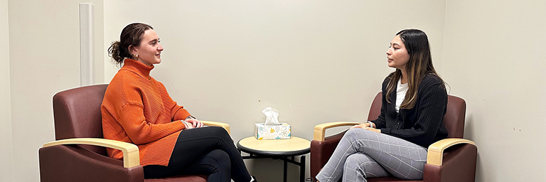 Counselor and client sit facing each other in a clinical setting