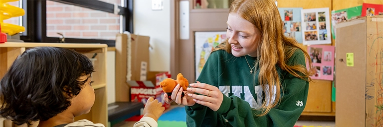 young teacher plays with a toddler