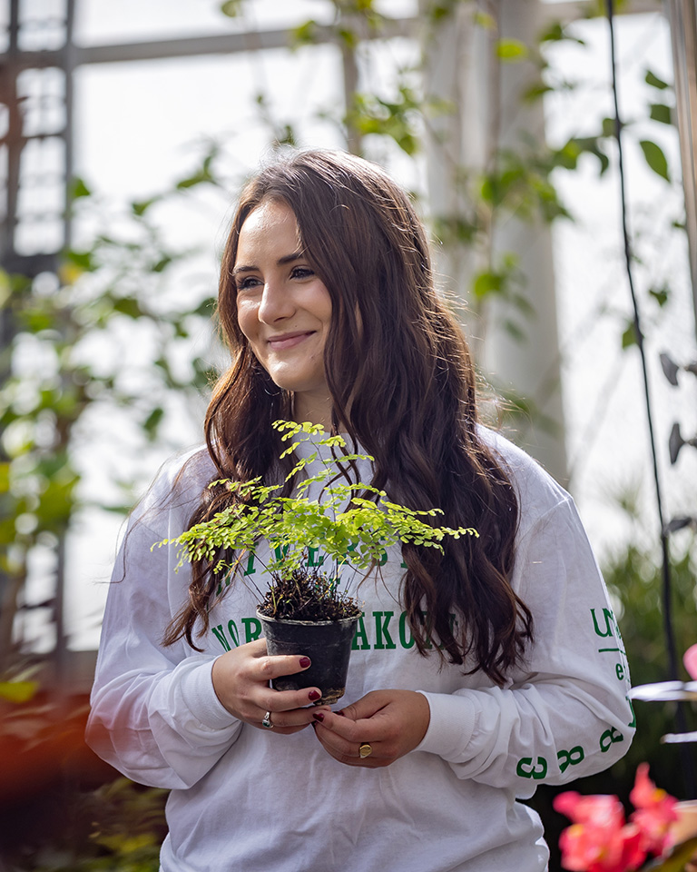 UND student in greenhouse